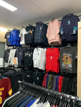 A black hoodie with a teal ’s’ logo and ’cavalier’ text on the front, hanging in a retail clothing store.