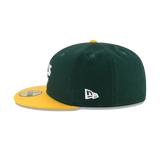 Green and yellow fitted baseball cap with flat brim and embroidered logo on the side