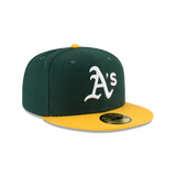 Green and yellow fitted baseball cap with white A's logo on the front.