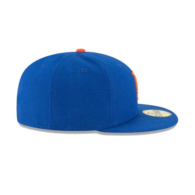 Blue fitted flat brim cap with orange top button and gold sticker, side view
