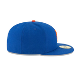 Blue fitted flat brim cap with orange top button and gold sticker, side view